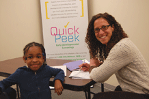 Amy Norton, Quick Peek program coordinator, works with the child 