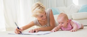  Smiling mother with her baby girl writting on a copybook