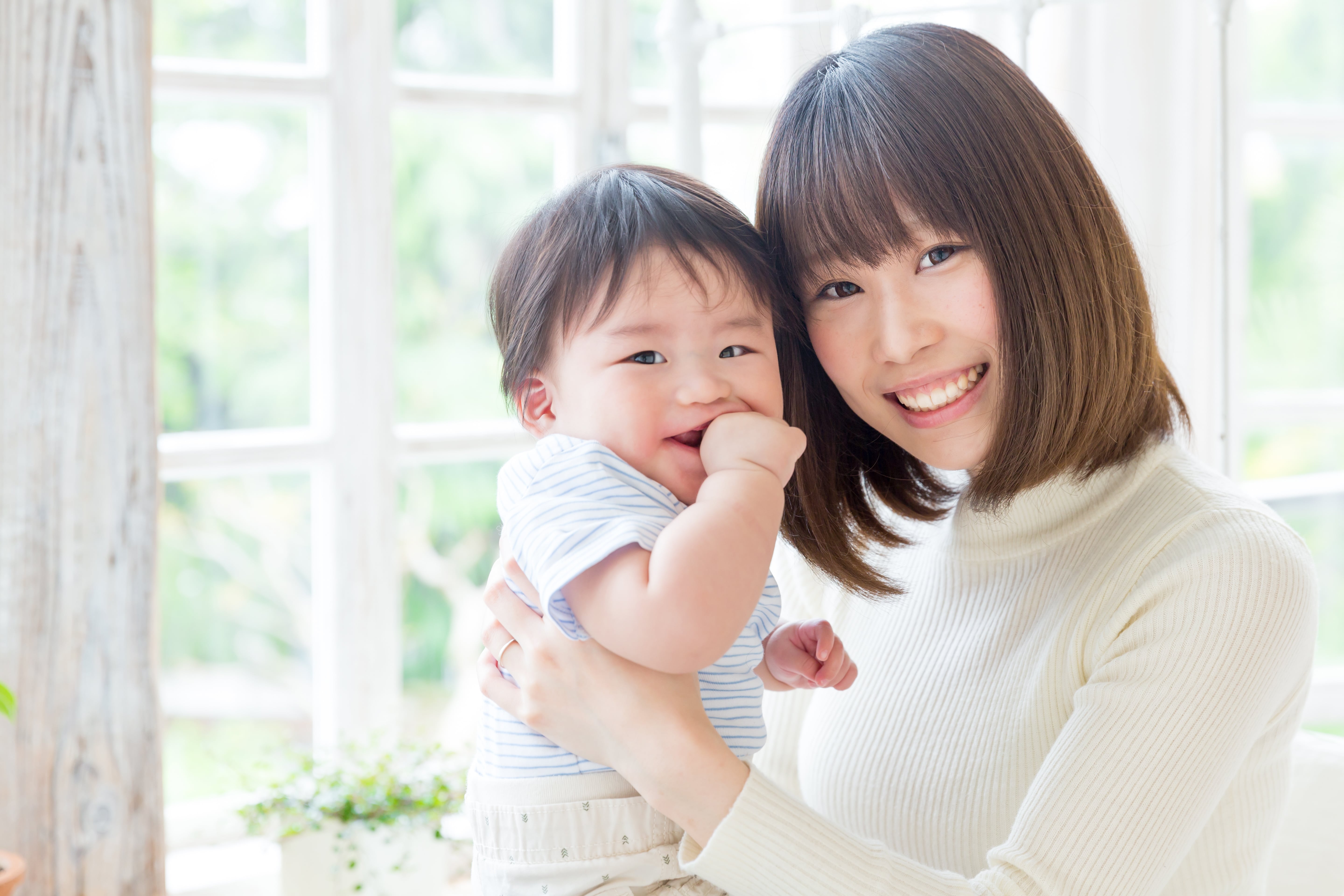 Photo of asian mother holding her young son in her arms