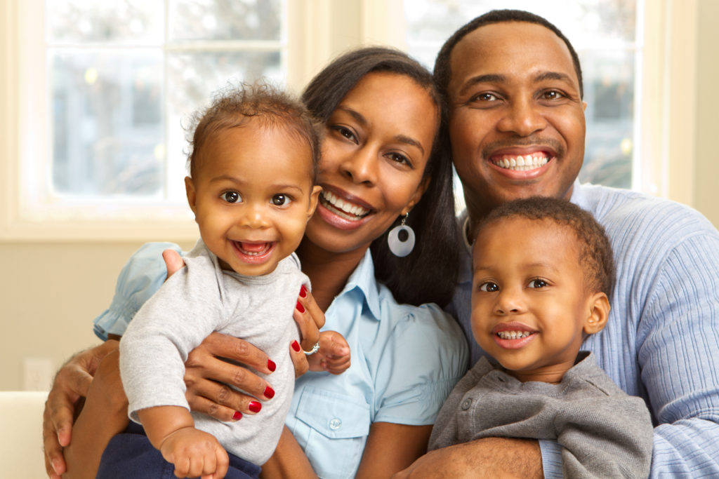 African American family smiling in front of a frosted window