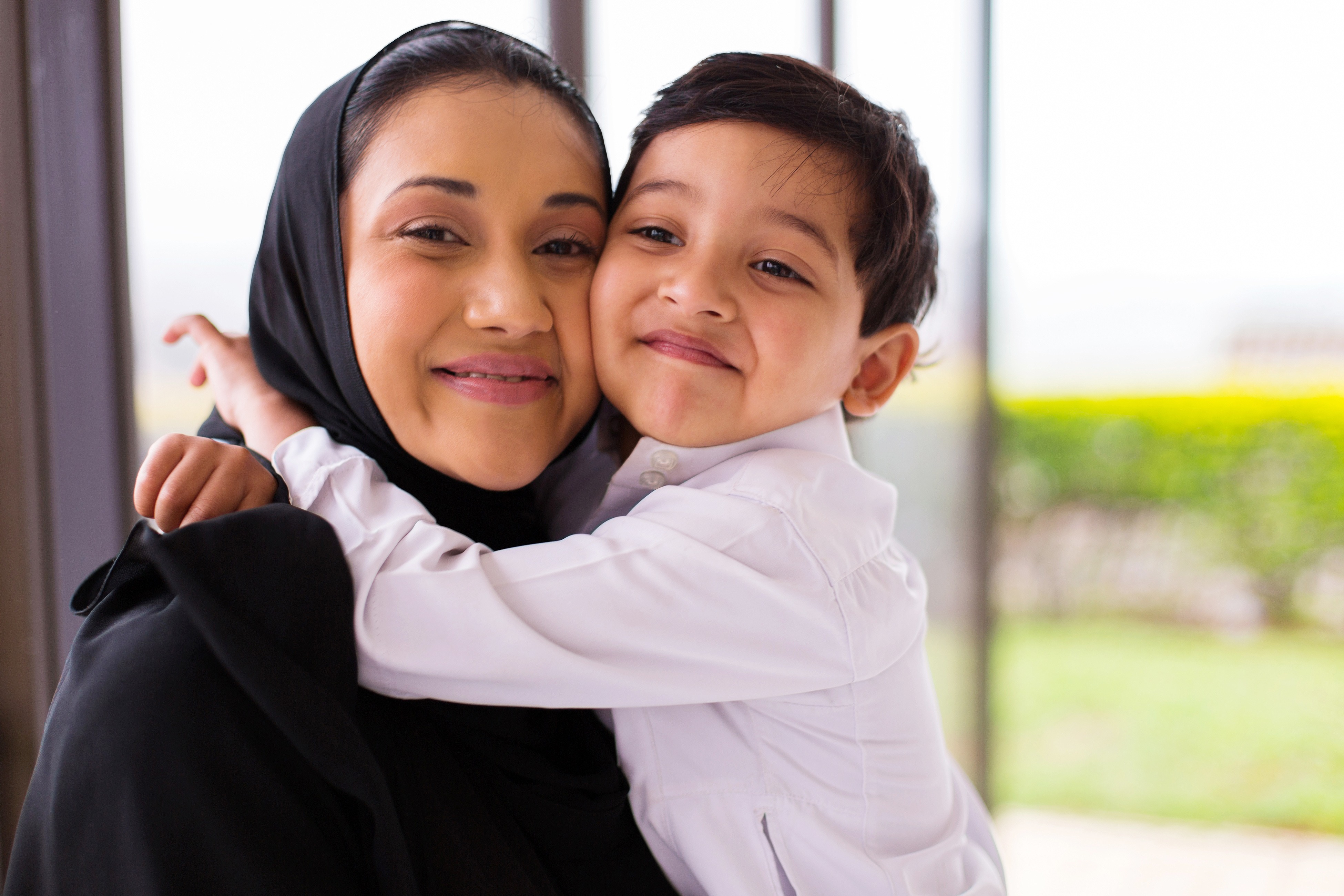 cute muslim boy hugging his mother