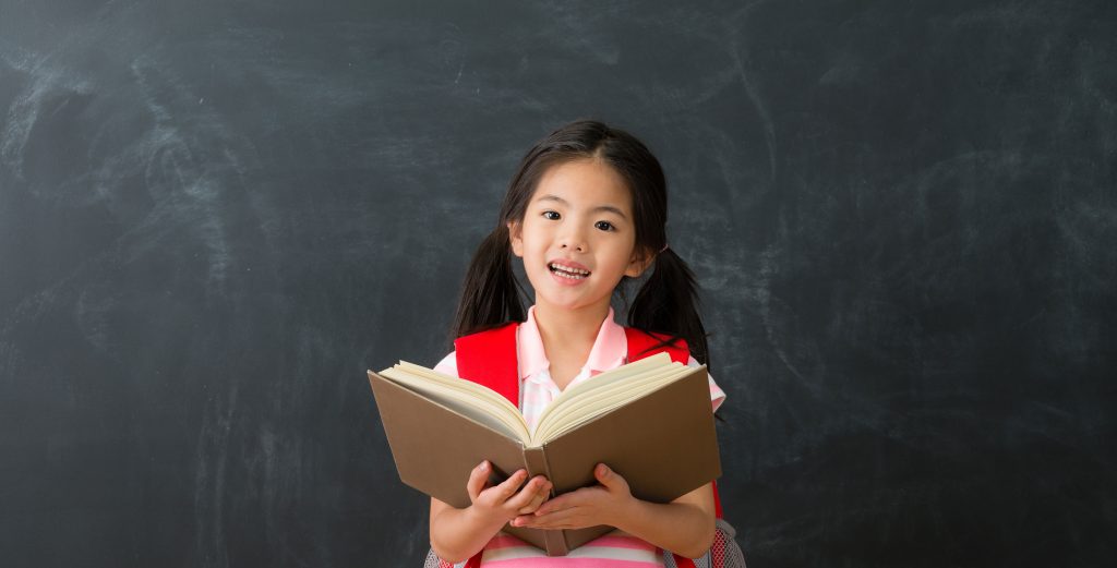 Young-girl-reading-book-in-class